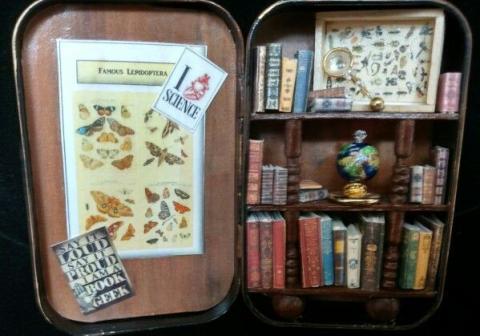 Tin containing a tiny library featuring small books.