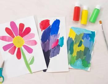 Display of watercolor paintings of a pink daisy, and two abstract creations.