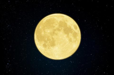 Gold colored autumn full moon against a black starry sky