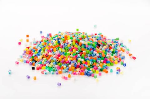 a pile of multi colored perler beads on a white background