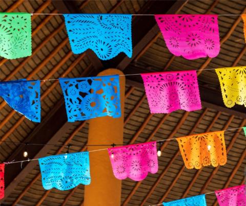 three rows of brightly colored paper banners strung across a ceiling