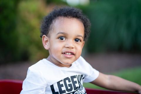 Photo of young black toddler with light complexion and a white t-shirt where the word "Legend" is partially in view