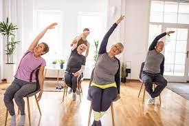 People seated in chairs stretching in a yoga pose