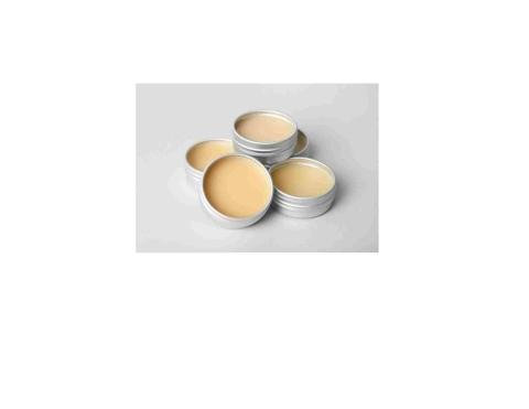 Round aluminum tins containing tan colored lip balm.