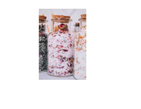 Close up of corked jars containing salt and dried flowers.