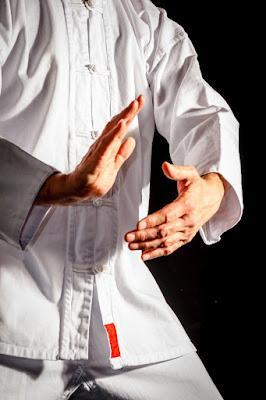 tai chi pracitoner in white, making a graceful move