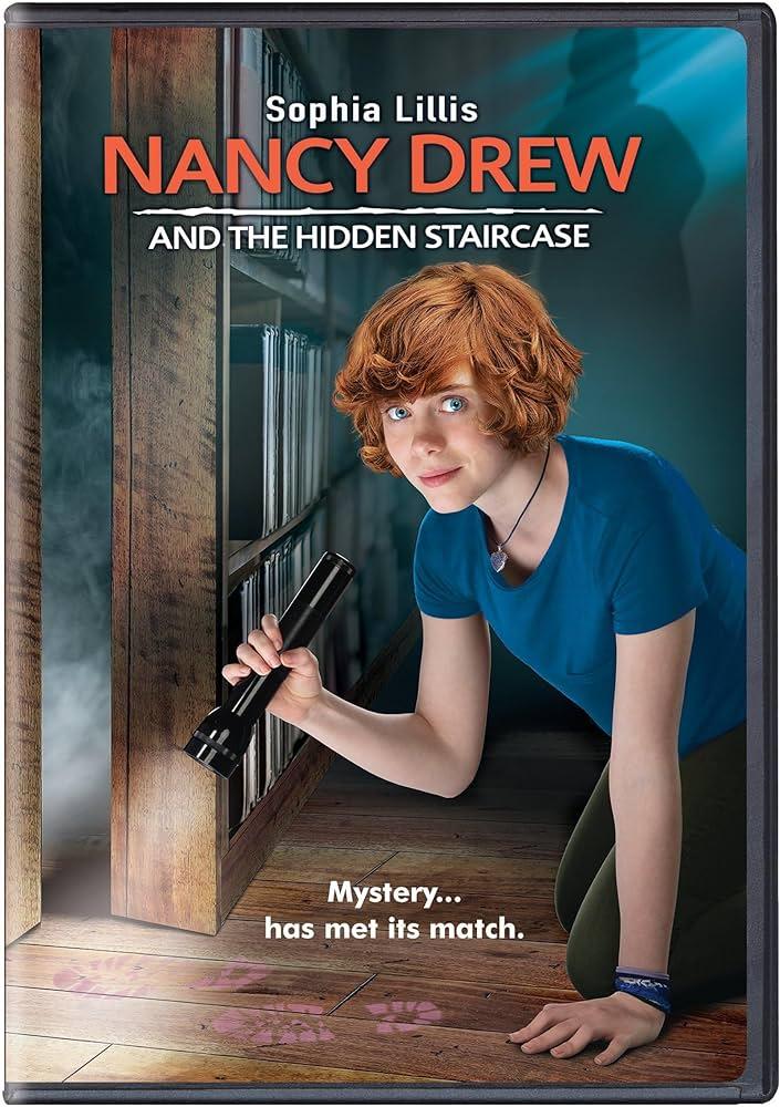 A red-haired teenager crouches on the floor, shining a flashlight under a door.