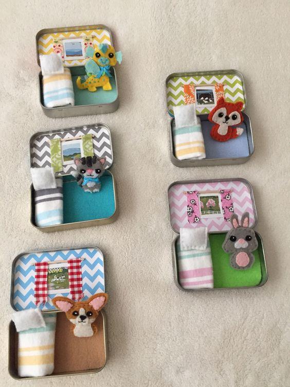 Photo of small mint-style tins decorated to look like tiny rooms for mini felt animals