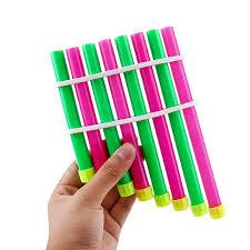 A hand holds up a  pan pipe created with alternating fluorescent colored straws.