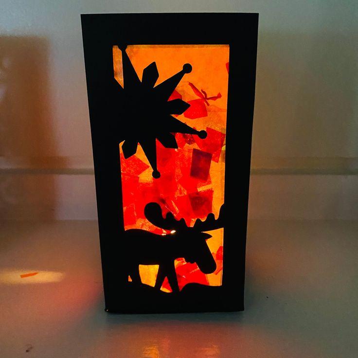 Photo of a paper lantern with a winter animal scene silhouetted against a glow