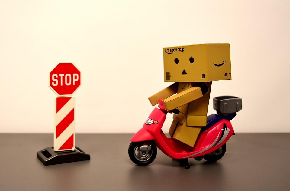a small cardboard figure on a red scooter next to a stop sign